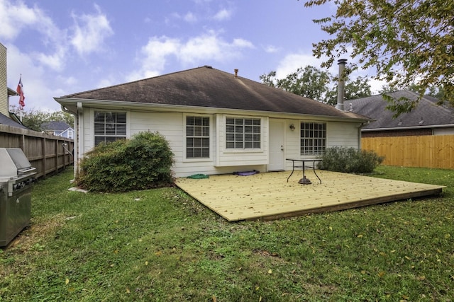 rear view of property with a wooden deck and a yard