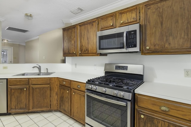 kitchen with appliances with stainless steel finishes, light tile patterned floors, crown molding, and sink