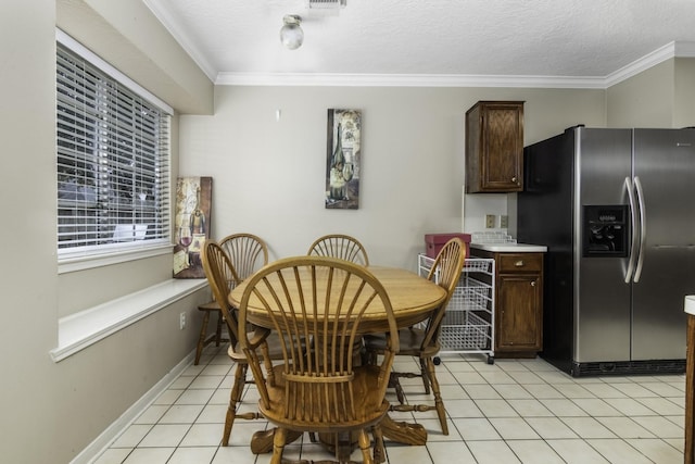 dining area featuring light tile patterned floors, a textured ceiling, and crown molding