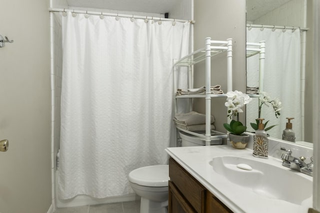 bathroom with tile patterned flooring, vanity, toilet, and walk in shower