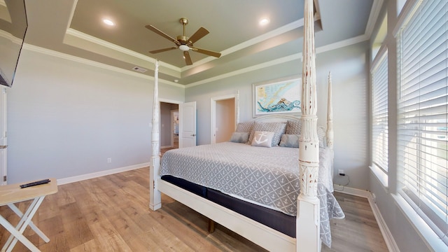 bedroom with wood-type flooring, a raised ceiling, ceiling fan, and ornamental molding