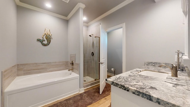 bathroom featuring hardwood / wood-style flooring, vanity, ornamental molding, and shower with separate bathtub