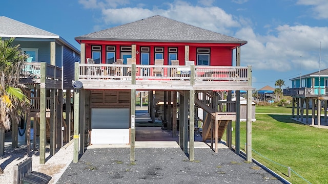 coastal inspired home with a carport, a front yard, and a deck