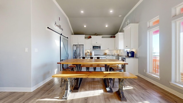 1819 Redfish Ln, Crystal Beach, TX 77650 - dining room featuring a barn door, baseboards, lofted ceiling, light wood-style floors, and recessed lighting