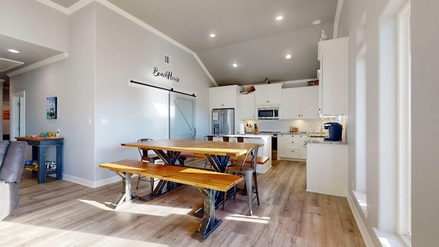 1819 Redfish Ln, Crystal Beach, TX 77650 - dining space with a barn door, light wood-style flooring, ornamental molding, recessed lighting, and baseboards