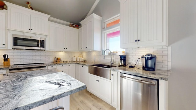 1819 Redfish Ln, Crystal Beach, TX 77650 - kitchen with stainless steel appliances, a sink, white cabinetry, light stone countertops, and light wood finished floors