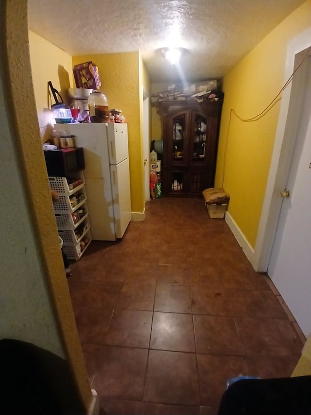 hallway with tile patterned floors and a textured ceiling