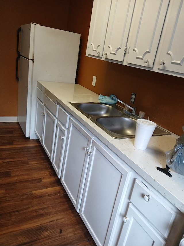 kitchen featuring dark hardwood / wood-style floors, white refrigerator, white cabinetry, and sink