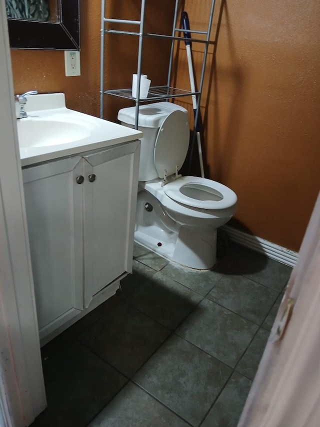 bathroom featuring tile patterned flooring, vanity, and toilet