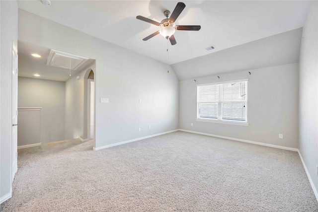 carpeted spare room featuring ceiling fan and vaulted ceiling