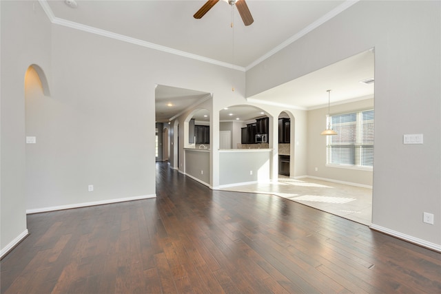 unfurnished living room with crown molding, ceiling fan, and dark hardwood / wood-style floors