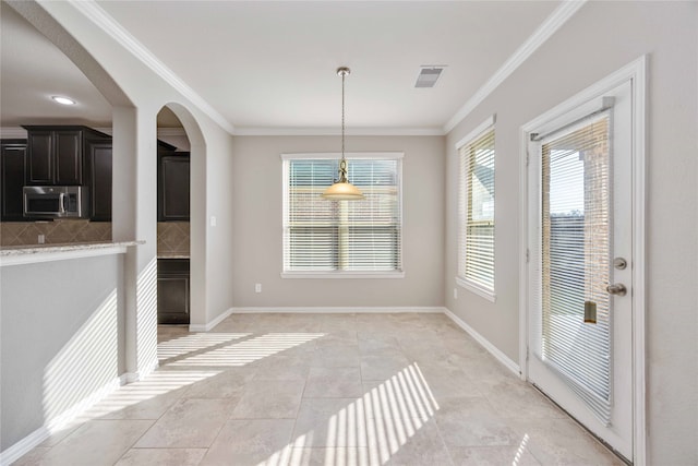 dining space featuring ornamental molding and light tile patterned flooring