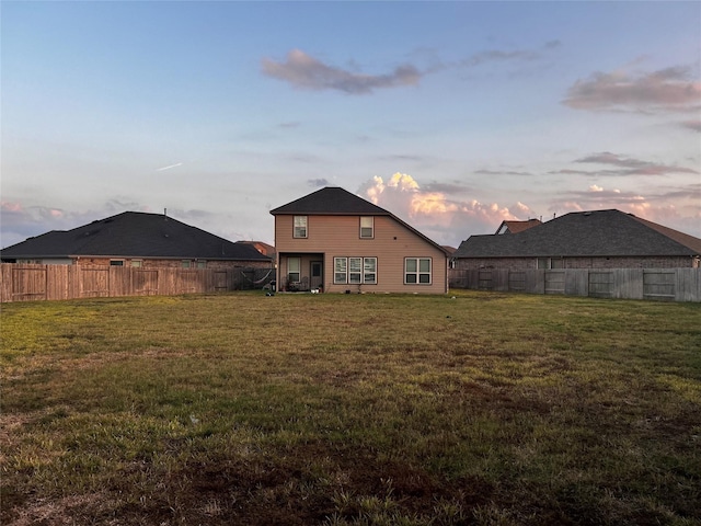 back house at dusk with a yard