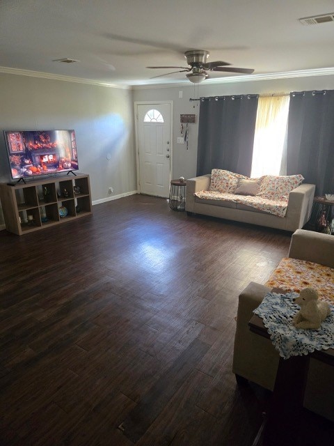 living room with dark hardwood / wood-style floors, ceiling fan, and crown molding