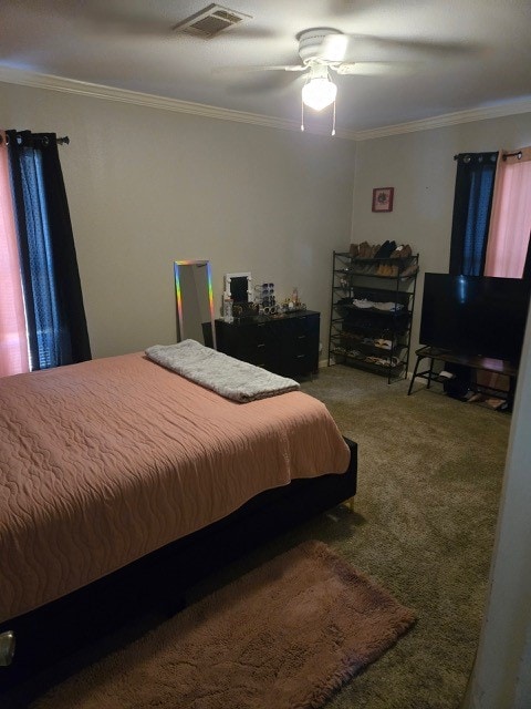 carpeted bedroom featuring ceiling fan and ornamental molding