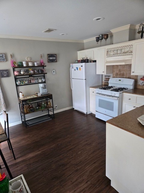 kitchen featuring crown molding, white cabinets, dark wood-type flooring, and white appliances