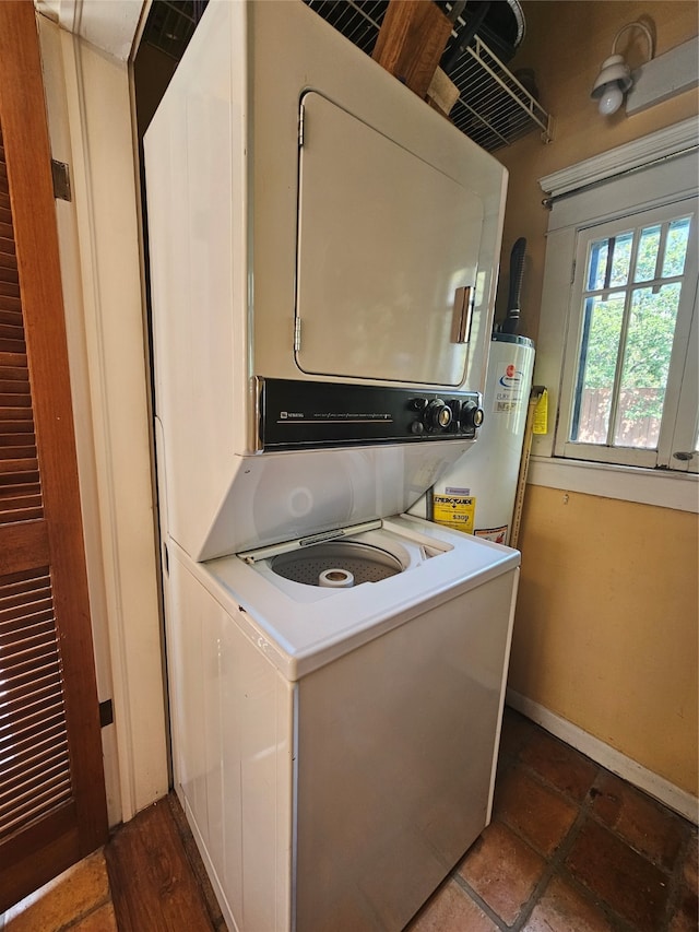 washroom featuring stacked washer / drying machine and water heater