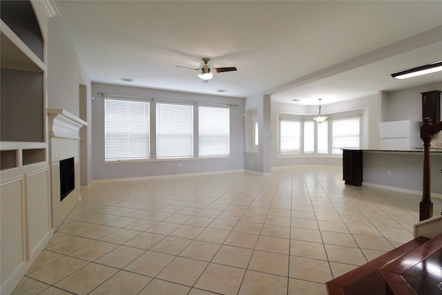 unfurnished living room featuring light tile patterned floors and ceiling fan