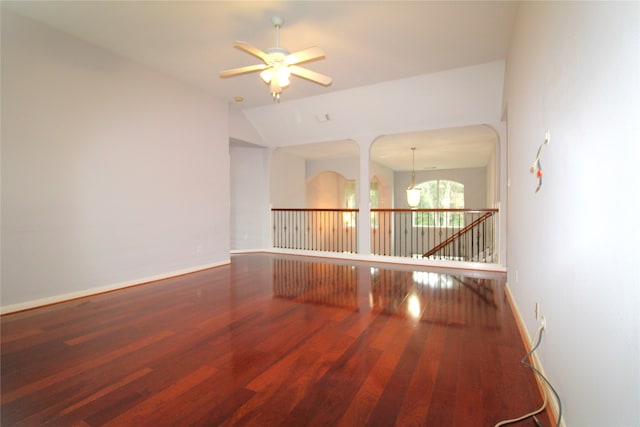 unfurnished room with hardwood / wood-style flooring, ceiling fan, and vaulted ceiling