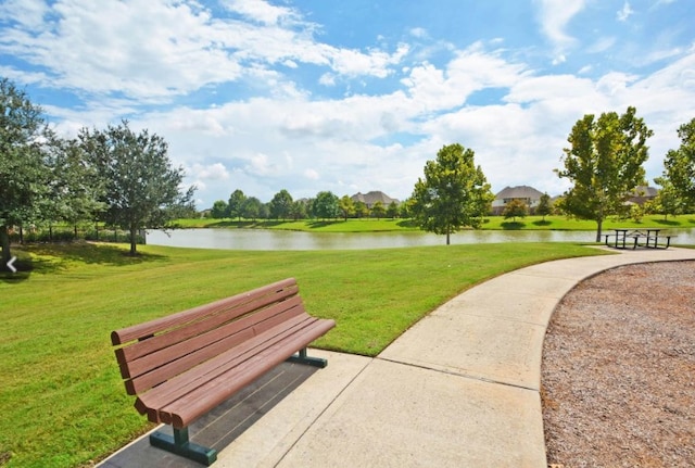 view of home's community featuring a lawn and a water view