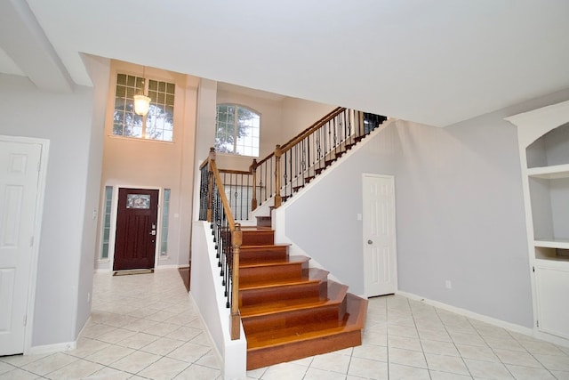 entryway featuring light tile patterned floors and a high ceiling