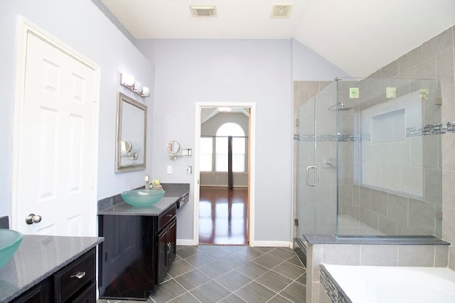 bathroom with tile patterned floors, vanity, vaulted ceiling, and shower with separate bathtub