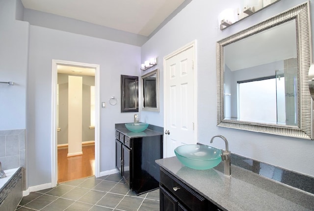 bathroom with tile patterned floors, a washtub, and vanity