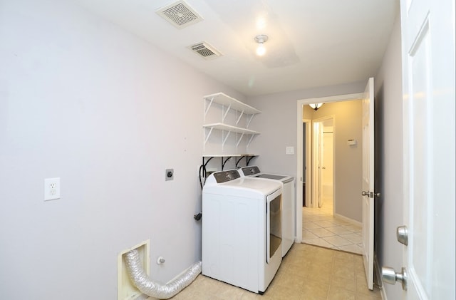 laundry area with washing machine and clothes dryer and light tile patterned flooring