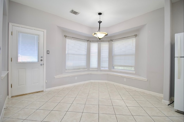 unfurnished dining area with plenty of natural light and light tile patterned flooring