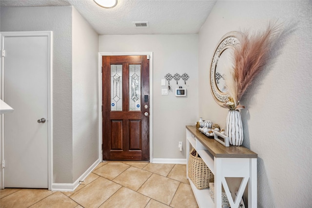 tiled entrance foyer with a textured ceiling