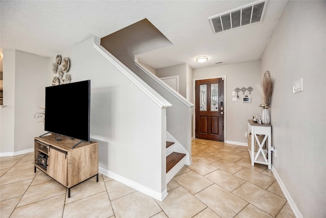 entryway featuring tile patterned flooring and a textured ceiling