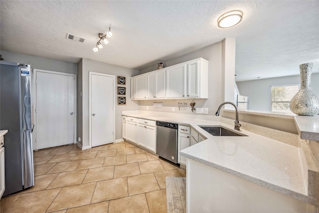 kitchen featuring light stone countertops, sink, stainless steel appliances, a textured ceiling, and white cabinets