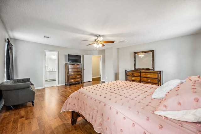 bedroom with connected bathroom, dark hardwood / wood-style floors, and ceiling fan