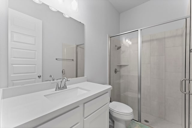 bathroom featuring vanity, toilet, and a shower with shower door