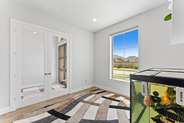 bedroom featuring french doors and light hardwood / wood-style flooring