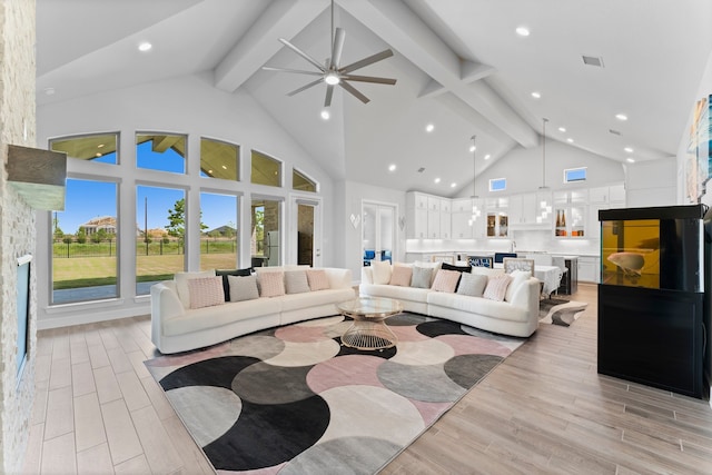 living room with beam ceiling, light wood-type flooring, high vaulted ceiling, and ceiling fan