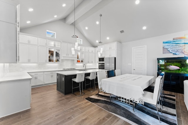 dining room with sink, high vaulted ceiling, beamed ceiling, and light wood-type flooring