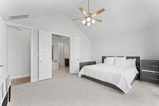 carpeted bedroom with ensuite bathroom, vaulted ceiling, and ceiling fan