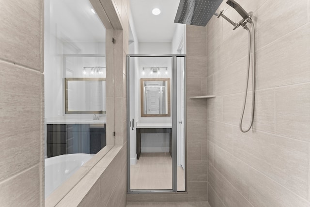 bathroom with tile walls and independent shower and bath