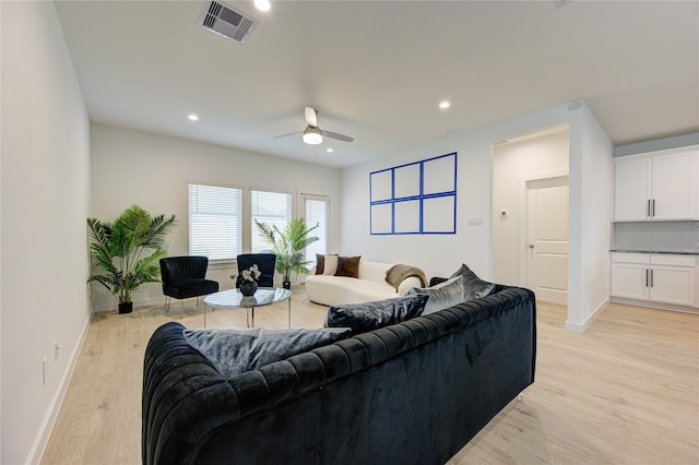 living room with light hardwood / wood-style floors and ceiling fan