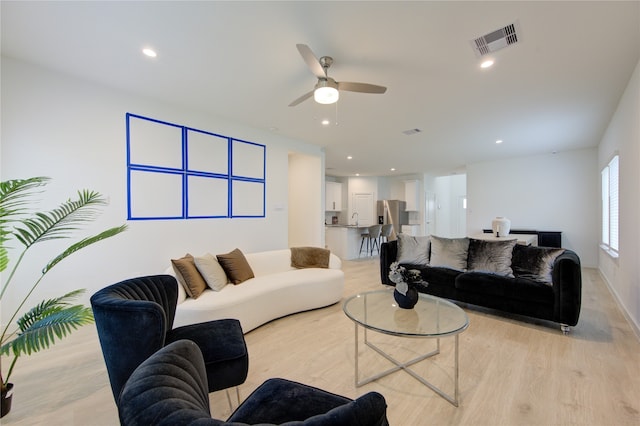 living room with light wood-type flooring and ceiling fan