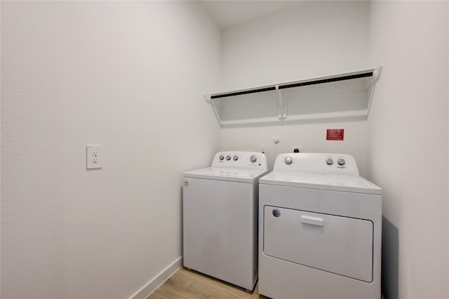 laundry room featuring washing machine and clothes dryer and light wood-type flooring