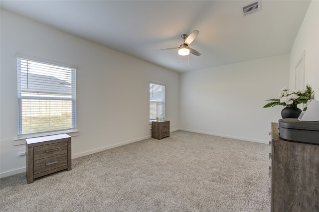 empty room with ceiling fan and light carpet