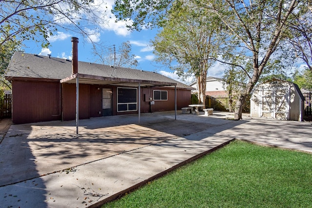 back of property featuring a storage unit and a patio