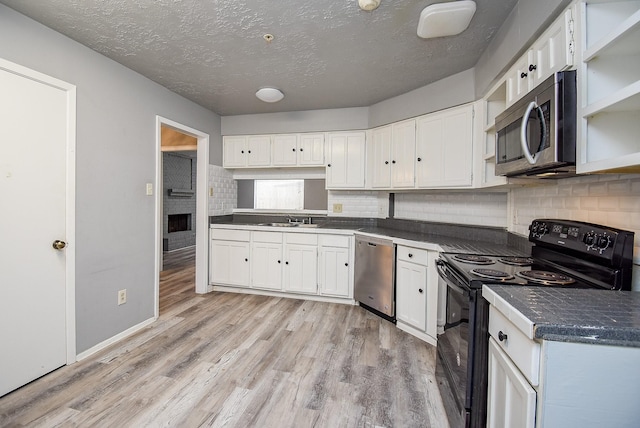 kitchen featuring a textured ceiling, stainless steel appliances, white cabinetry, and sink