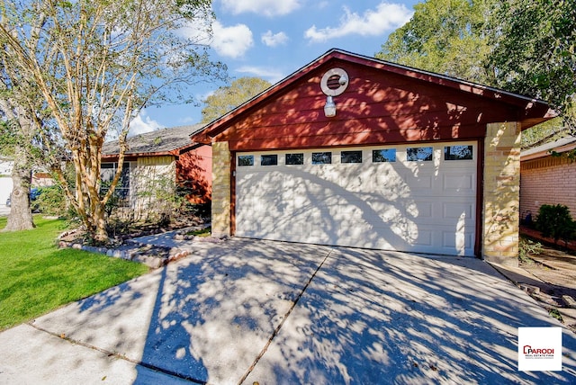 view of front facade with a garage, a front lawn, and an outdoor structure