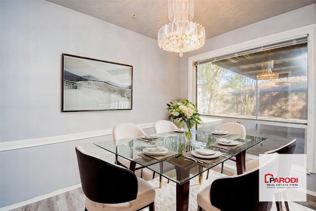 dining space featuring hardwood / wood-style floors and a chandelier