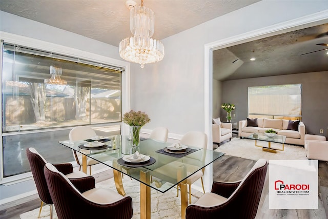 dining room with lofted ceiling, an inviting chandelier, and hardwood / wood-style floors