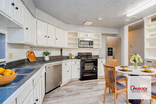 kitchen with white cabinets, light wood-type flooring, appliances with stainless steel finishes, and sink