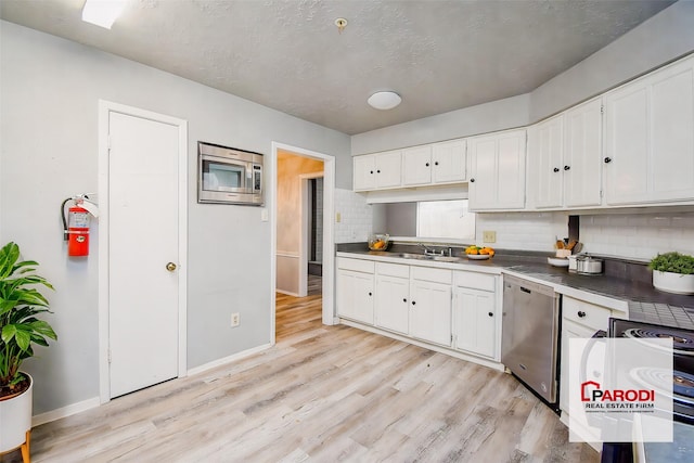 kitchen with decorative backsplash, sink, white cabinetry, and stainless steel appliances